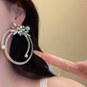 Close-up detail of vintage silver needle rhinestone drop earrings with pearls on model