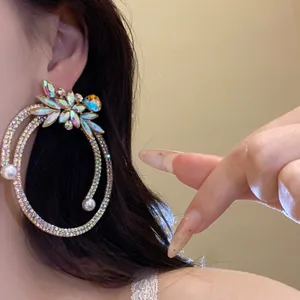 Detail view showing the intricate rhinestone and pearl design of the hoop earring