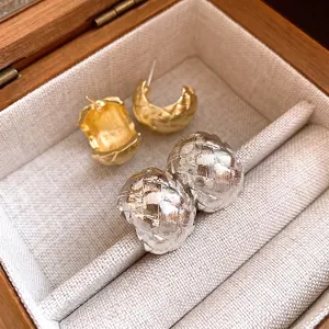 Boucles d'oreilles créoles rétro texturées en or et argent dans une boîte à bijoux