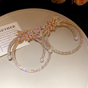 Detailed close-up of sparkling crystal and pearl double-hoop earrings on a stylish plate