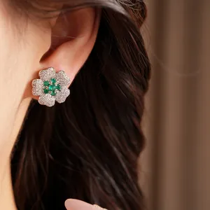 Detailed close-up view of a vintage flower stud earring with green and white zircon stones