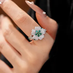Detailed macro view of a silver flower ring with sparkling green and white zircons