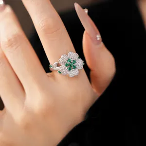 Close-up detail of an elegant flower ring featuring green and sparkling clear zircon stones.
