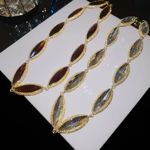 Close-up detail of luxury oval crystal spliced necklaces in amber and grey blue