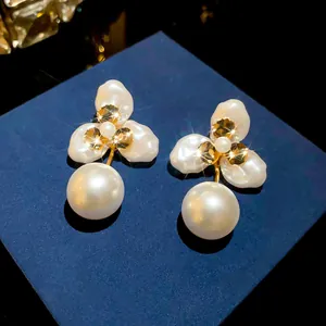 Detail view of 18k gold plated petal pearl earrings with sparkling crystal accents