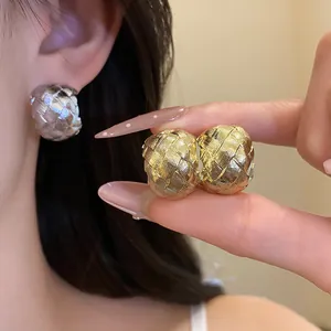 Gros plan de boucles d'oreilles créoles en C texturées vintage dorées et argentées