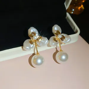 Close-up of French retro 18k gold plated petal earrings with elegant white pearl drops