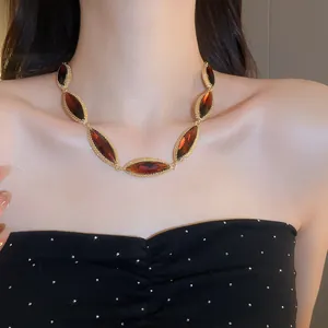Close-up of a vintage-style gold necklace with marquise-cut amber gemstones on a model
