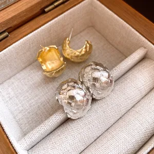 Vue détaillée de la texture tressée des boucles d'oreilles vintage en forme de C or et argent