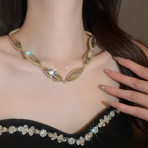 Close-up of elegant marquise-cut crystal necklace with gold-tone chain and flower detailing.