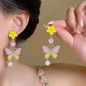 Exquisite macro view of colorful butterfly earrings with flower and pearl drops.