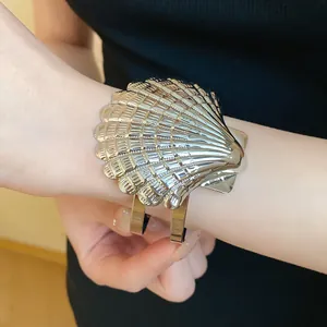 Primer plano detallado de un brazalete abierto vintage con forma de concha metálica