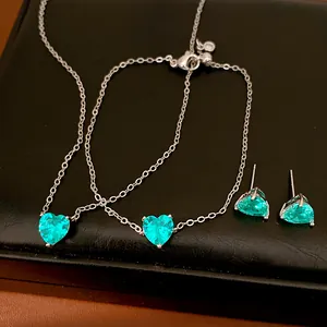 Elegant jewelry set with green heart-shaped gemstones on a minimalist silver chain