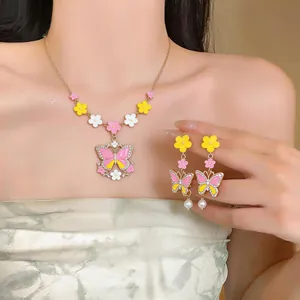 Detailed view of elegant enamel butterfly and flower necklace and earring set on model