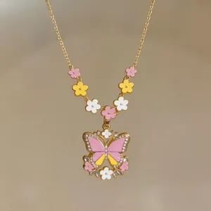 Close-up of butterfly pendant necklace with colorful enamel flowers in gold finish