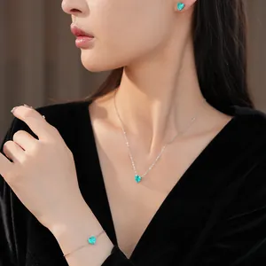Close-up of elegant green heart zircon necklace, earrings, and bracelet set on a model