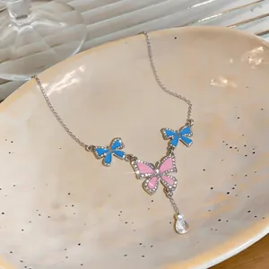 Close-up of enamel butterfly pendant necklace with sparkling crystal and diamond accents