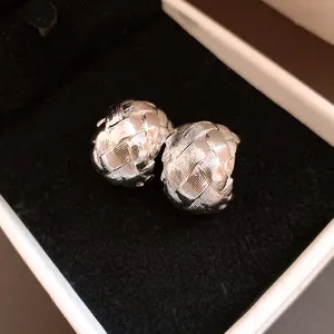 Détail de la texture tissée complexe sur des boucles d'oreilles créoles vintage en argent