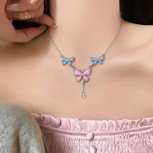 Detail of enamel butterfly pendant necklace with bow charms and water drop accent