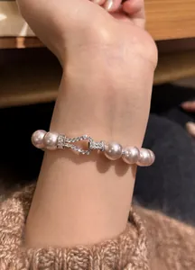 Close-up of elegant pink pearl bracelet with zircon horse-bit clasp on wrist