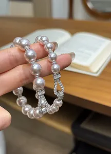 Close-up detail showing the high-luster pearls and zircon-encrusted luxury U-link clasp