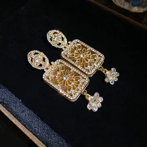 Close-up of vintage court style gold rectangular dangle earrings with rhinestones