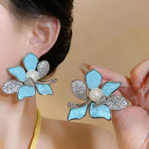 Elegant flower stud earrings with blue enamel petals, central pearl and zircon accents
