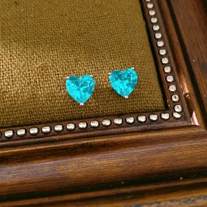 Detailed macro shot of heart-shaped cyan zircon earrings in a vintage frame