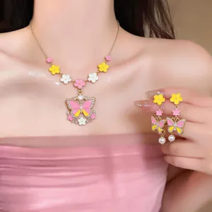 Detailed view of elegant pink enamel butterfly necklace and matching pearl earrings