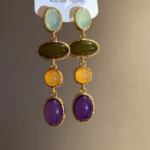 Close-up of vintage multi-colored resin pendant earrings with gold textured frames