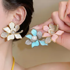 Detailed view of floral pearl earrings in white, blue, and pink with zircon accents