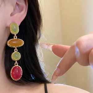 Detailed close-up view of vintage oval resin drop earrings with colorful multi-stone cabochons