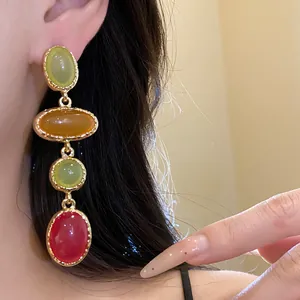 Close-up of vintage multi-colored oval resin drop earrings displayed on a model