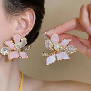 Detailed view of pink flower stud earrings with CZ stones and central white pearl.