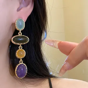 Detail shot of vintage-style drop earrings featuring colorful oval resin stones