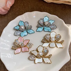 Detailed view of floral stud earrings with pearls and shimmering zirconia petals.