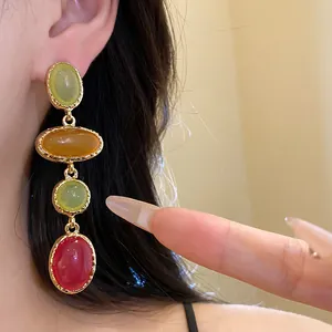 Detailed macro view of multi-colored vintage resin oval drop earrings in gold setting