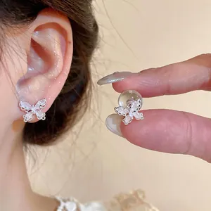 Exquisite Schmetterlings-Ohrstecker aus Silber mit funkelnden Zirkoniasteinen am Ohr.
