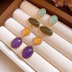 Close-up of vintage multi-color oval resin drop earrings with gold settings