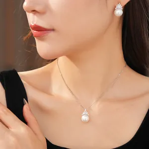 Gros plan sur l'ensemble collier et boucles d'oreilles en perles de zircon plaqué or 18 carats