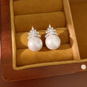 Détails des boucles d'oreilles en perles et zircons plaquées or 18k dans un écrin