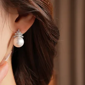 Gros plan d'une élégante boucle d'oreille en perle et zircon plaquée or 18 carats