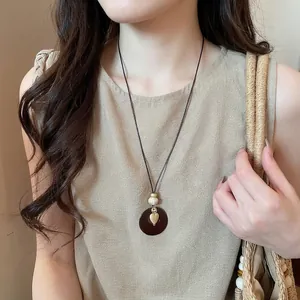 Bohemian vintage round heart pendant necklace worn by a model in casual chic style.