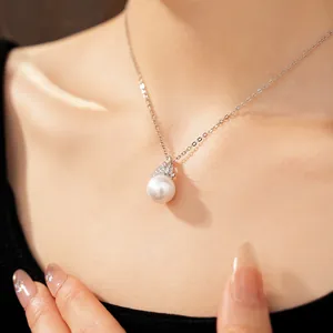 Détail élégant d'un collier de perles avec oxydes de zirconium sur une chaîne argentée