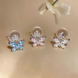 Nahaufnahme von drei zierlichen Zirkonia-Schmetterlingssteckern in Blau, Rosa und Weiß.