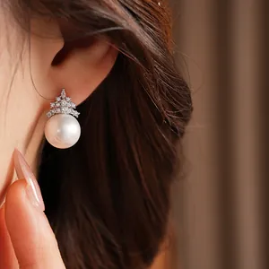 Gros plan d'une élégante puce d'oreille en perle avec des accents de zircons brillants