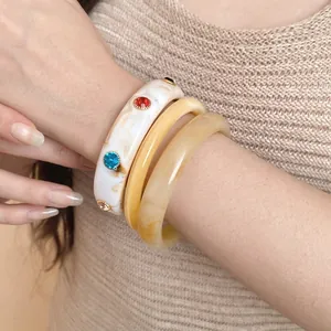 Set van retro gemarmerde acryl armbanden met edelsteen inleg op een vrouwelijk model