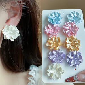 Detalle del juego de pendientes de botón con flores dopamina en varios colores