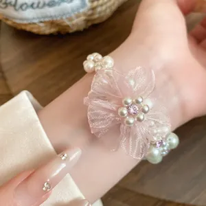 Gros plan d'un bracelet en perles multicouches orné d'une grande fleur en mousseline rose