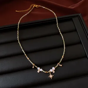 Close-up of a handmade beaded necklace featuring white pearls and a gold star charm